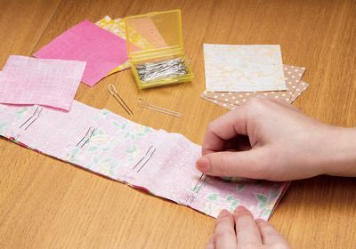 Fork pins in use, pinning together fabric on a wooden table